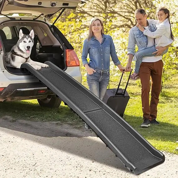 Husky resting in an SUV boot with the ramp set up, family loading luggage
